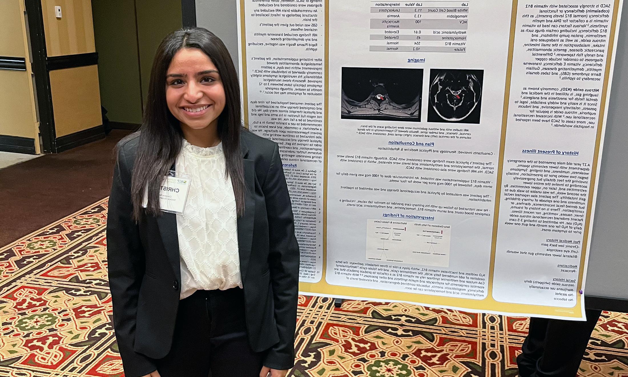 An image of Christine Simon in front of her research poster