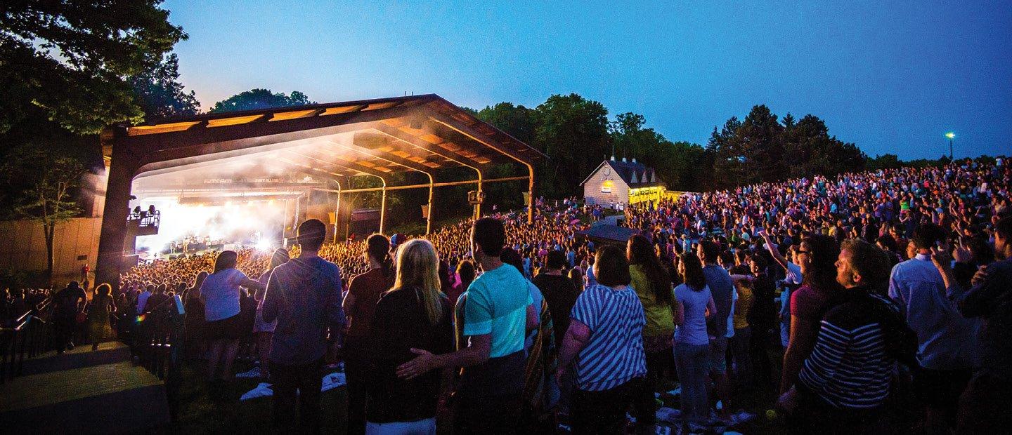 Large crowd on the lawn of Meadow Brook Music Festival, watching an outdoor concert.